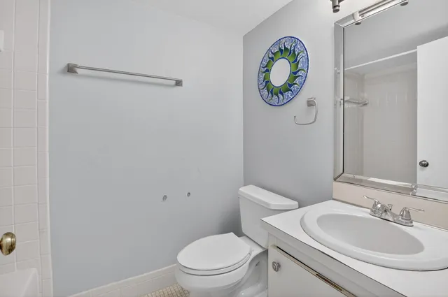 a bathroom with a toilet a sink and a mirror