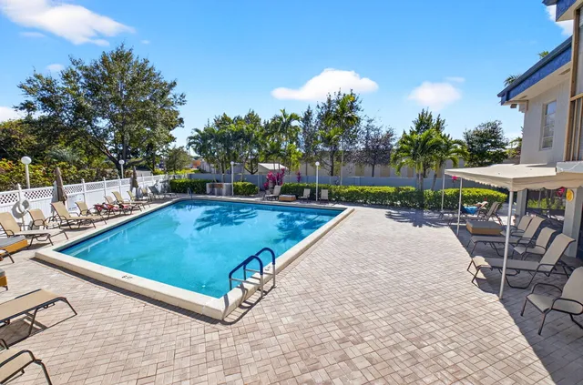 a view of a swimming pool with a patio and a yard