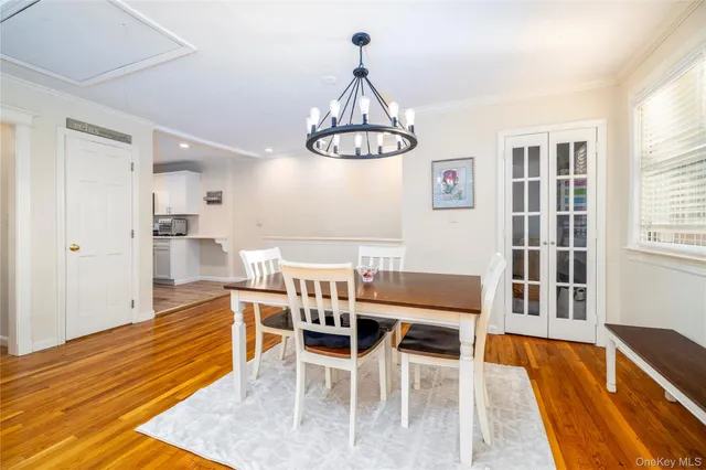 a dining room with wooden floor and a chandelier