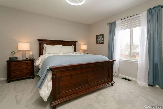 9772 Quay Loop Westminster, CO 80021 - Photo 22 of 36 a bed sitting in a bedroom next to a window