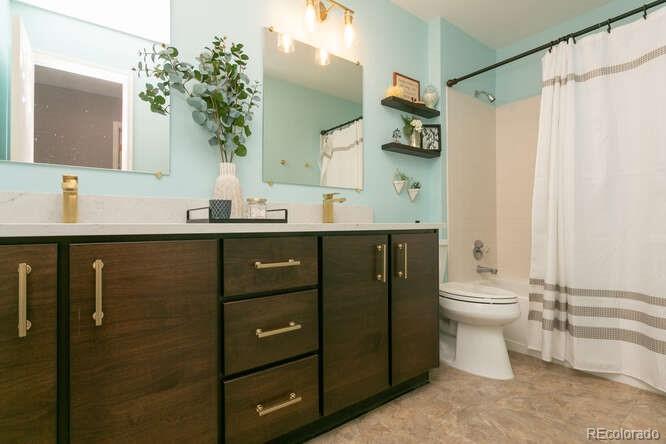 9772 Quay Loop Westminster, CO 80021 - Photo 23 of 36 a bathroom with a sink a toilet and shower