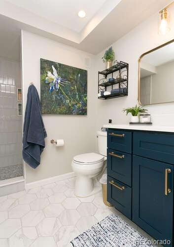 9772 Quay Loop Westminster, CO 80021 - Photo 30 of 36 a bathroom with a toilet sink and mirror