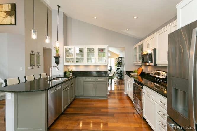 9772 Quay Loop Westminster, CO 80021 - Photo 6 of 36 a kitchen with stainless steel appliances granite countertop a stove a sink and a refrigerator