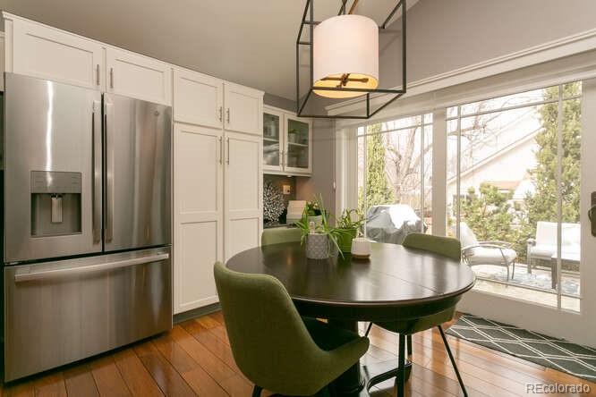 9772 Quay Loop Westminster, CO 80021 - Photo 8 of 36 a dining room with furniture a chandelier and wooden floor