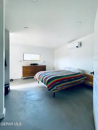a bedroom with a bed and a lamp on desk