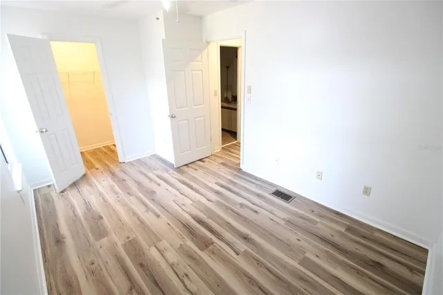 a view of empty room with wooden floor