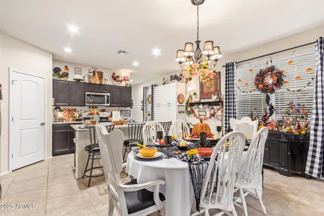 a view of a dining room and livingroom with furniture wooden floor a chandelier