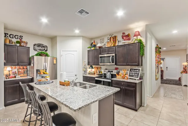 a kitchen with stainless steel appliances kitchen island granite countertop a table and chairs in it