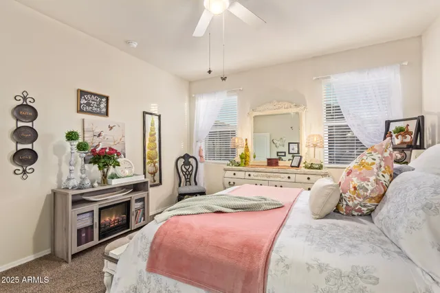 a spacious bedroom with a bed a chandelier and a flat screen television