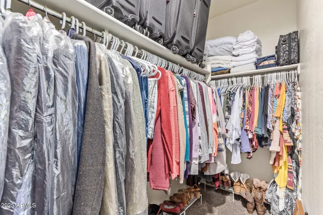 a view of walk in closet with clothes