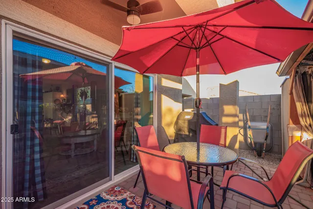 a view of swimming pool with a table and chairs under an umbrella
