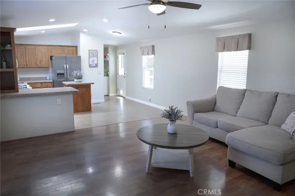 a living room with stainless steel appliances kitchen island furniture and a wooden floor