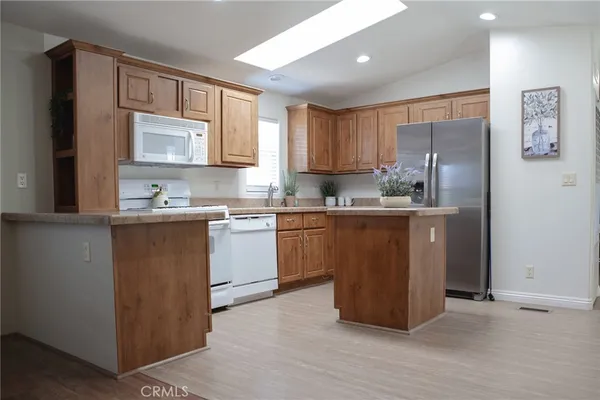 a kitchen with a refrigerator sink and cabinets