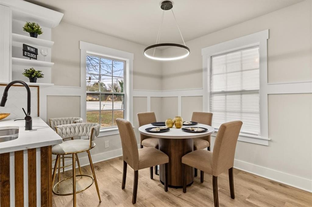 4203 Annistown Road Snellville, GA 30039 - Photo 11 of 32 a dining room with furniture a chandelier and wooden floor