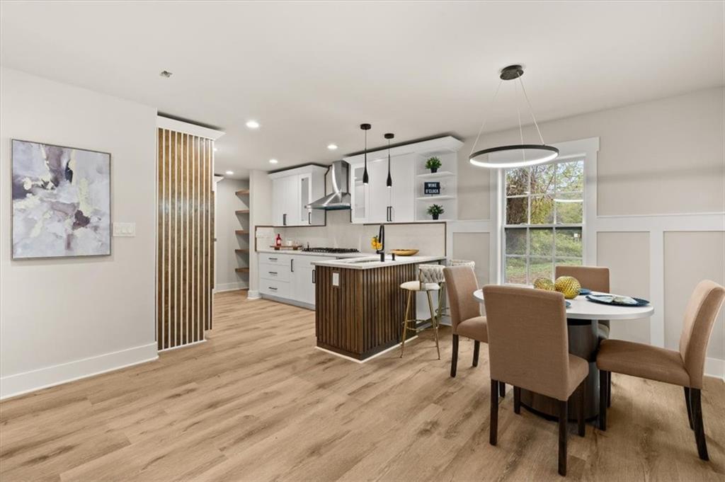 4203 Annistown Road Snellville, GA 30039 - Photo 12 of 32 a living room with stainless steel appliances kitchen island granite countertop furniture and wooden floor