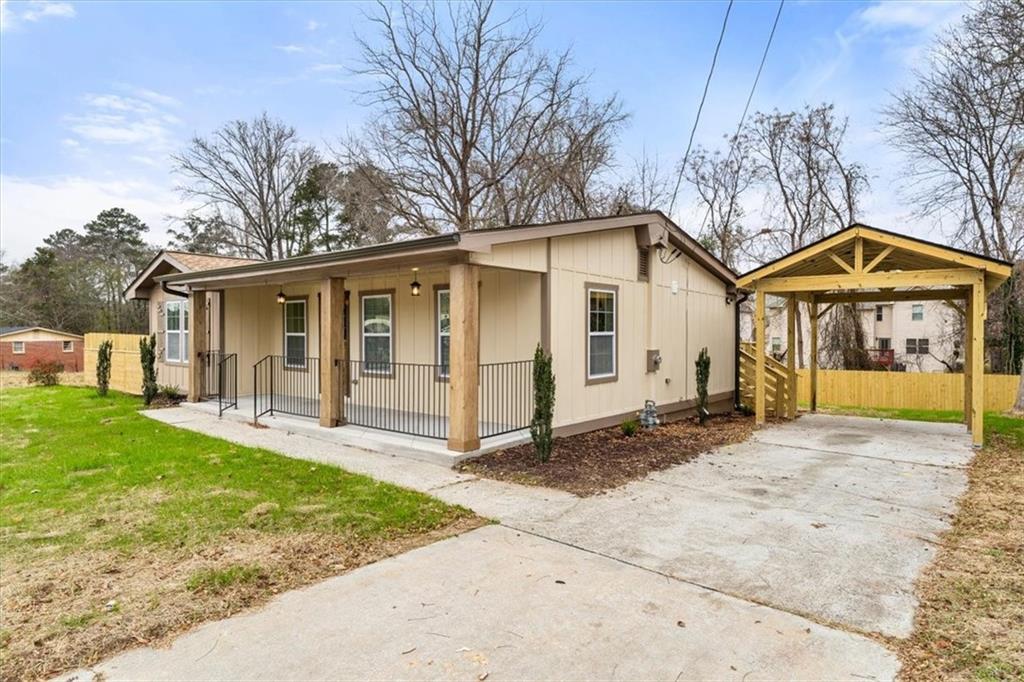 4203 Annistown Road Snellville, GA 30039 - Photo 23 of 32 a view of a white house with a big yard and large trees