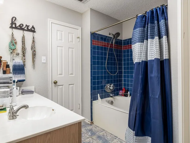 a bathroom with a sink vanity granite tub shower and a mirror