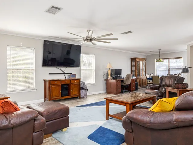a living room with furniture kitchen view and a flat screen tv