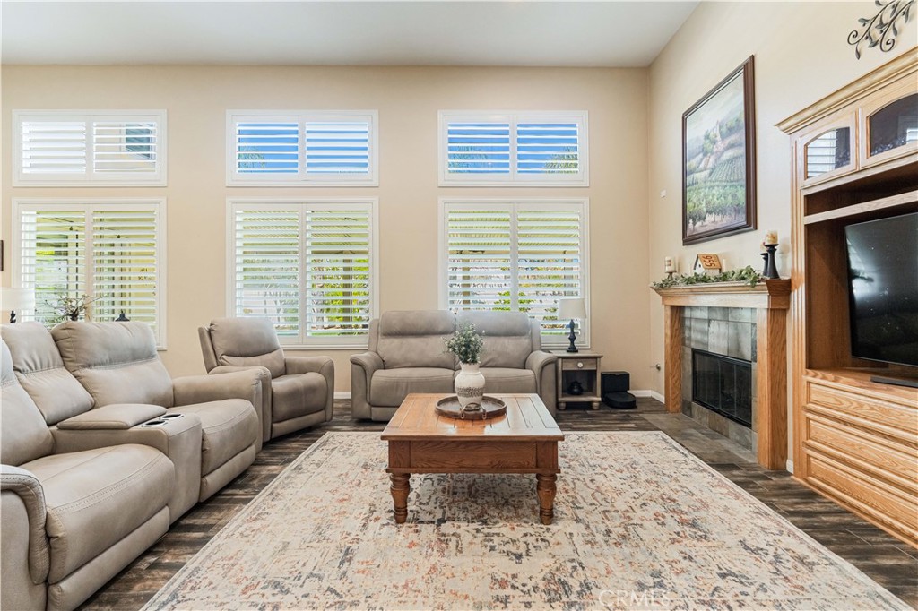 32016 Woodside Court Temecula, CA 92592 - Photo 15 of 40 a living room with furniture a rug a fireplace and windows