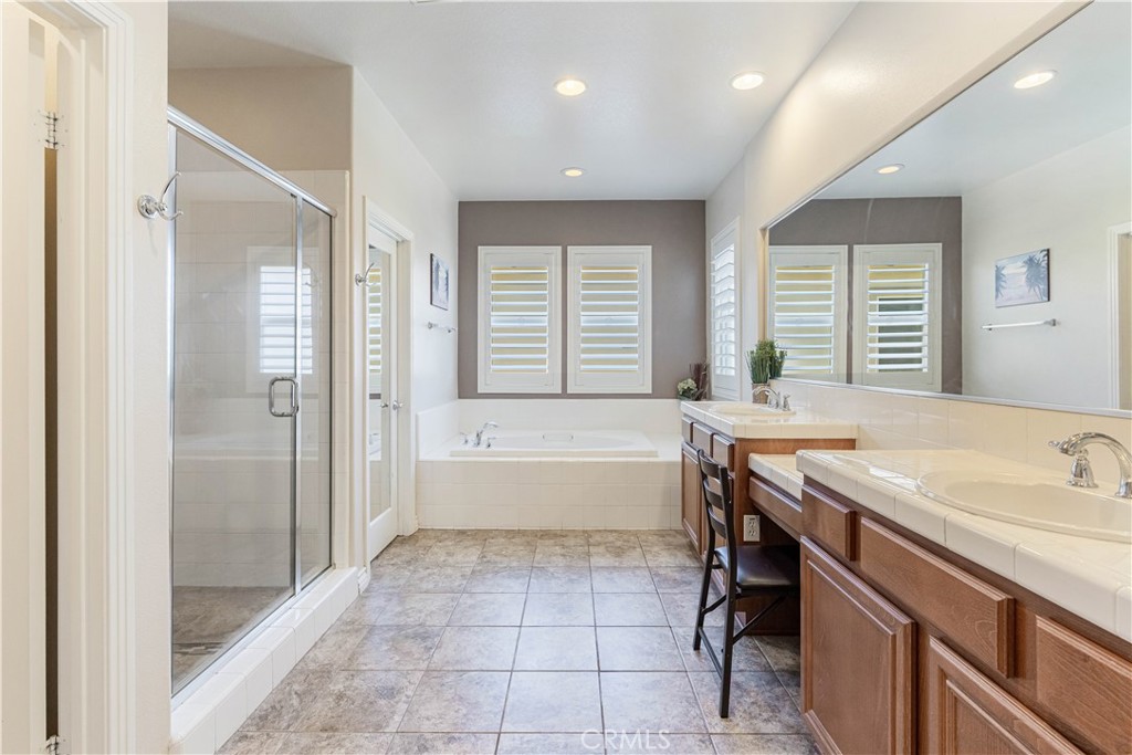 32016 Woodside Court Temecula, CA 92592 - Photo 19 of 40 a spacious bathroom with a granite countertop tub sink shower and mirror