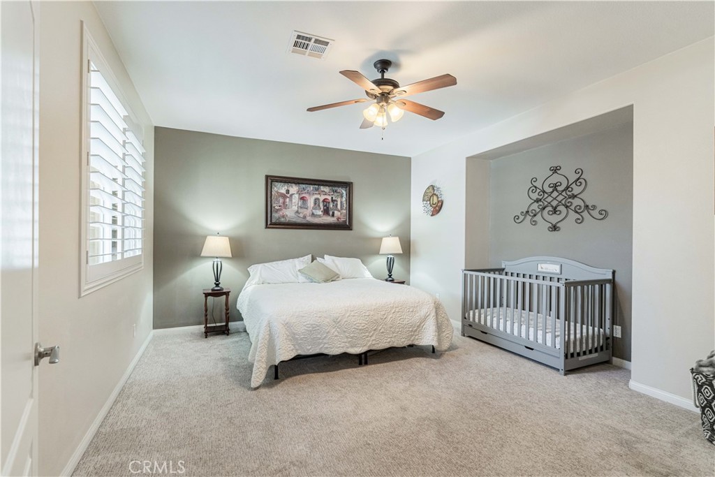 32016 Woodside Court Temecula, CA 92592 - Photo 21 of 40 a bedroom with a bed and a chandelier