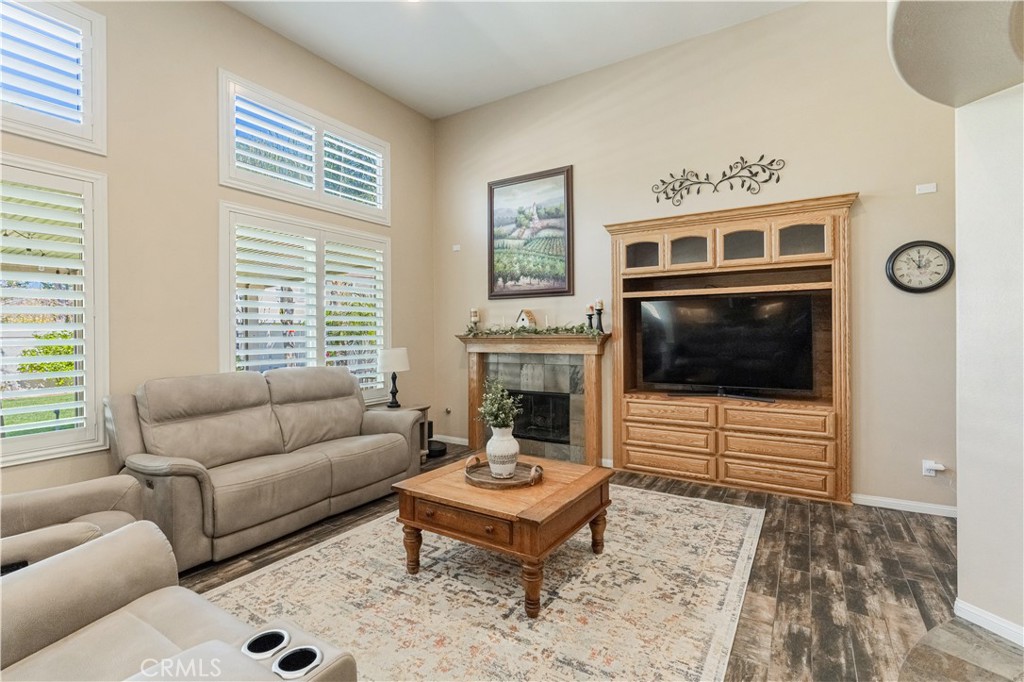 32016 Woodside Court Temecula, CA 92592 - Photo 10 of 40 a living room with furniture a flat screen tv and a fireplace
