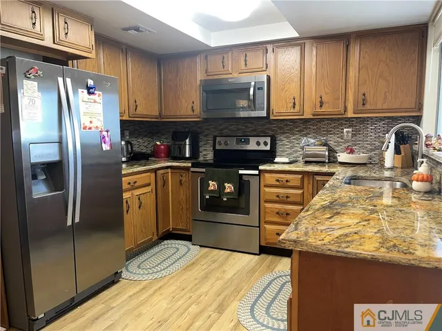 a kitchen with stainless steel appliances granite countertop a refrigerator stove and sink
