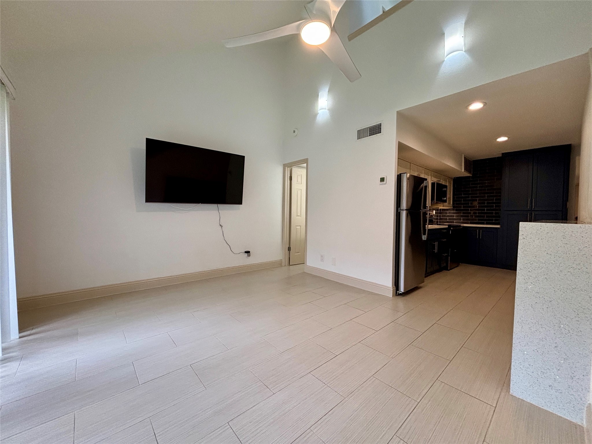 12900 Walden Road, Unit 508E Montgomery, TX 77356 - Photo 10 of 25 a living room with a flat screen tv and a refrigerator