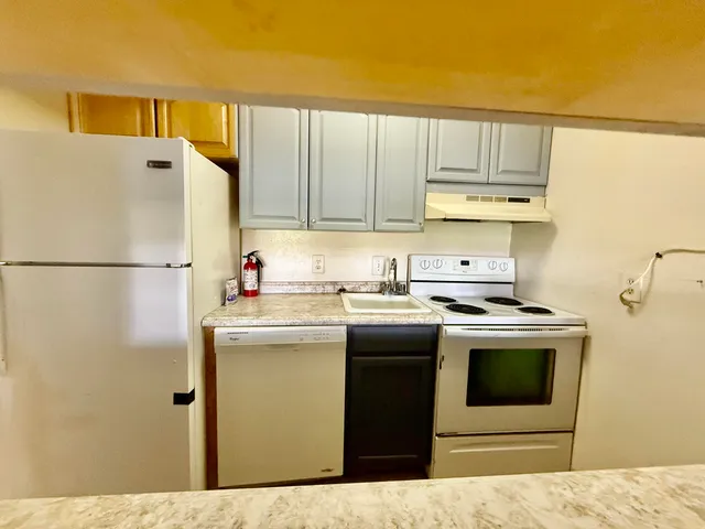 a kitchen with a sink a stove top oven and cabinets