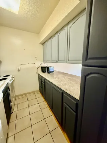 a kitchen with a refrigerator a stove top oven and cabinets