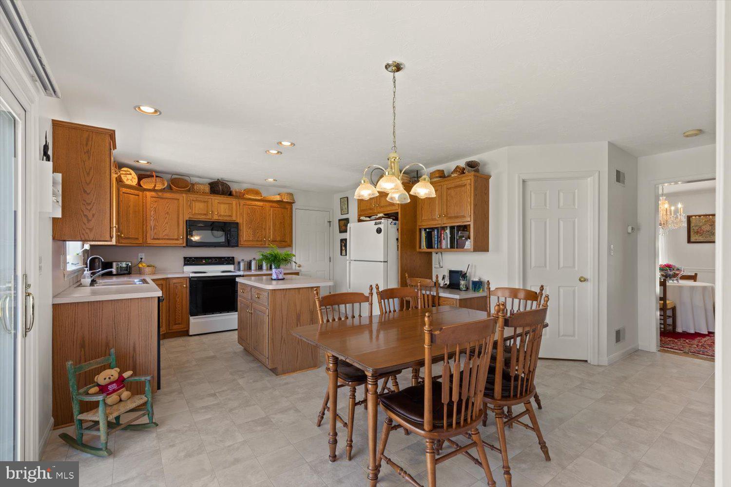 34 Ream Road Stevens, PA 17578 - Photo 9 of 53 a view of a dining room and livingroom with furniture wooden floor a rug a flat screen tv a painting and a chandelier