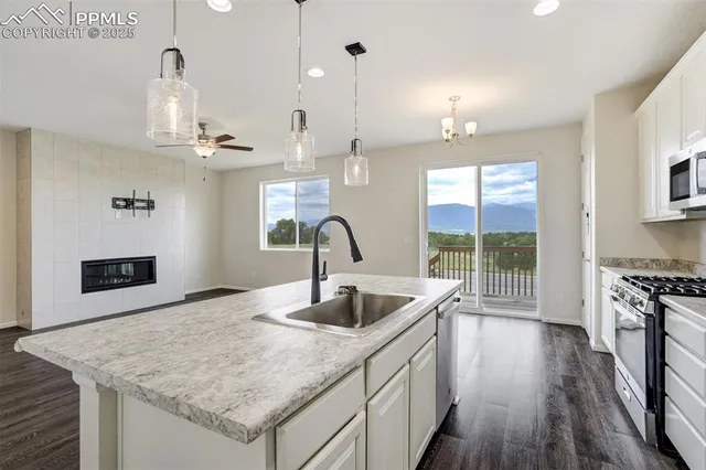 a kitchen with stainless steel appliances granite countertop a sink dishwasher and a stove with wooden floor