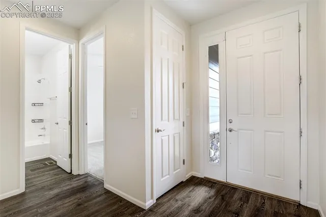 an empty room with wooden floor & windows
