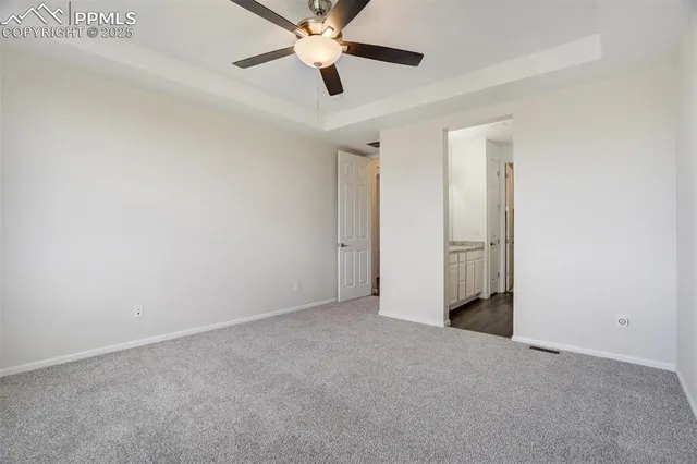an empty room with closet and a ceiling fan