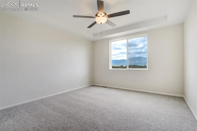 an empty room with a window and a fan
