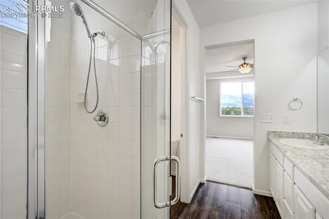 a bathroom with a granite countertop shower a mirror and a sink