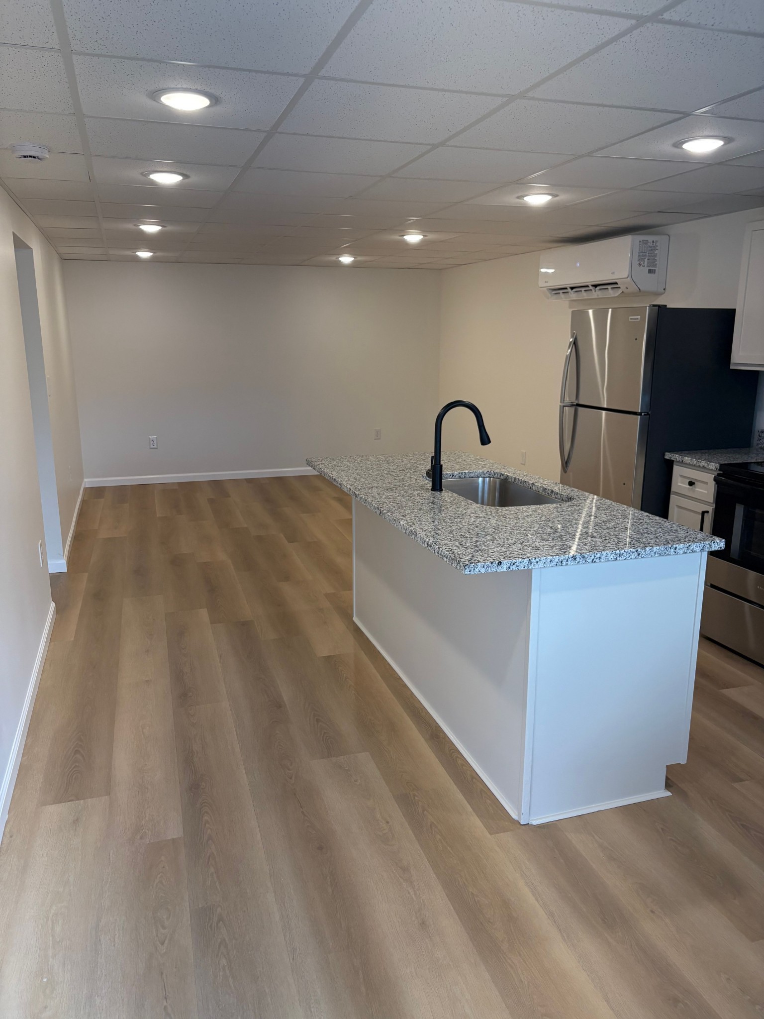 606 Dover Road, Unit 1 Clarksville, TN 37042 - Photo 3 of 12 a kitchen with kitchen island a sink wooden floor and a refrigerator