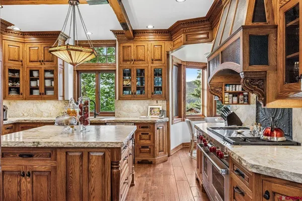 a kitchen with stainless steel appliances granite countertop a stove and a wooden floors
