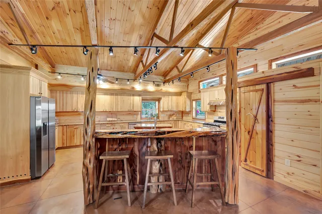 a dining table with chairs and kitchen view