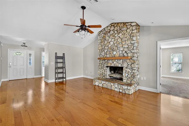 a view of an empty room with a fireplace and window