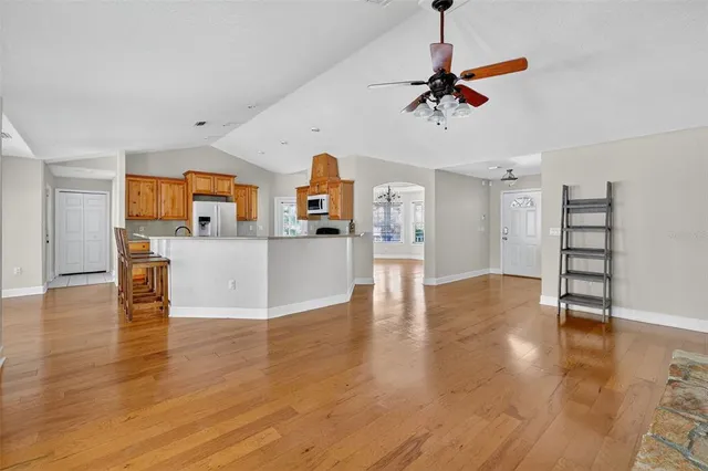 a view of a livingroom with a furniture wooden floor and a ceiling fan