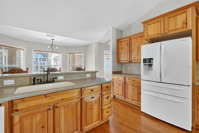 a kitchen with granite countertop cabinets stainless steel appliances a sink and a window