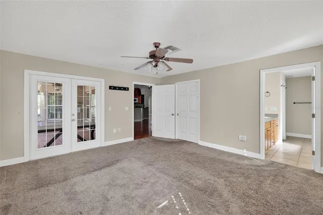 a view of a livingroom with a chandelier fan and windows