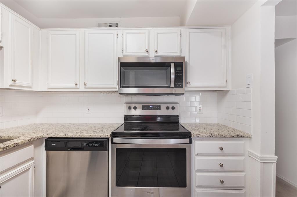 8750 Park Lane, Unit 151 Dallas, TX 75231 - Photo 14 of 33 a kitchen with granite countertop white cabinets and stainless steel appliances