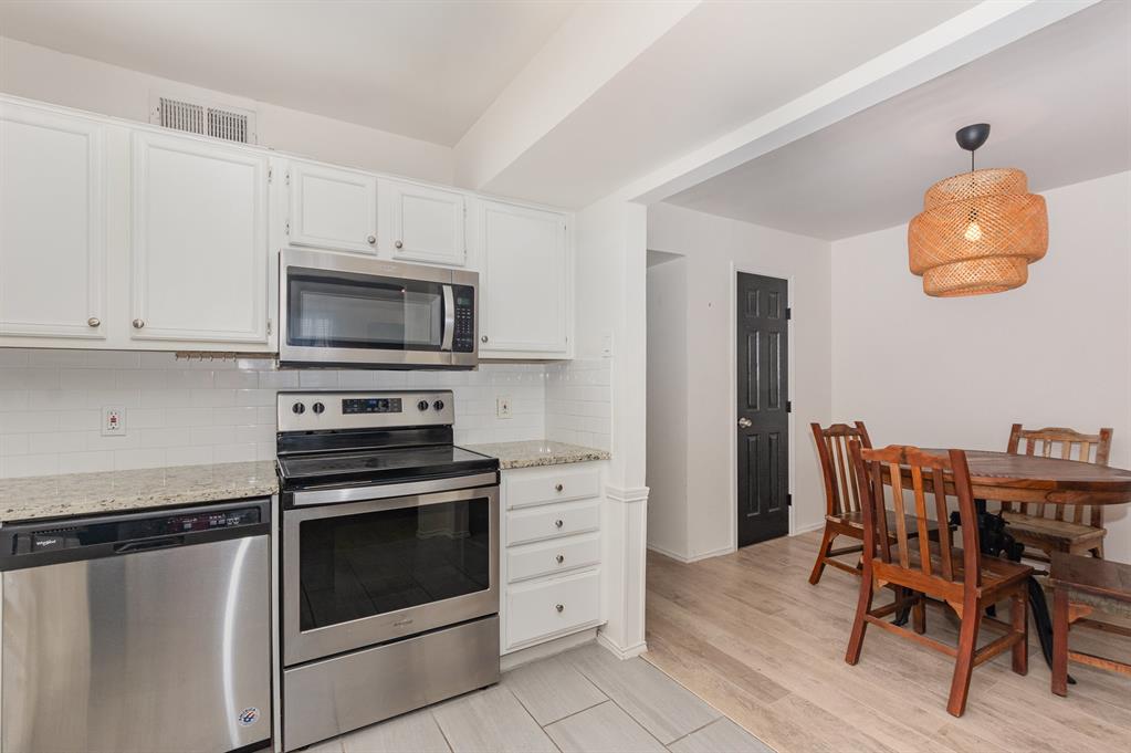 8750 Park Lane, Unit 151 Dallas, TX 75231 - Photo 15 of 33 a kitchen with stainless steel appliances a stove a microwave and a refrigerator