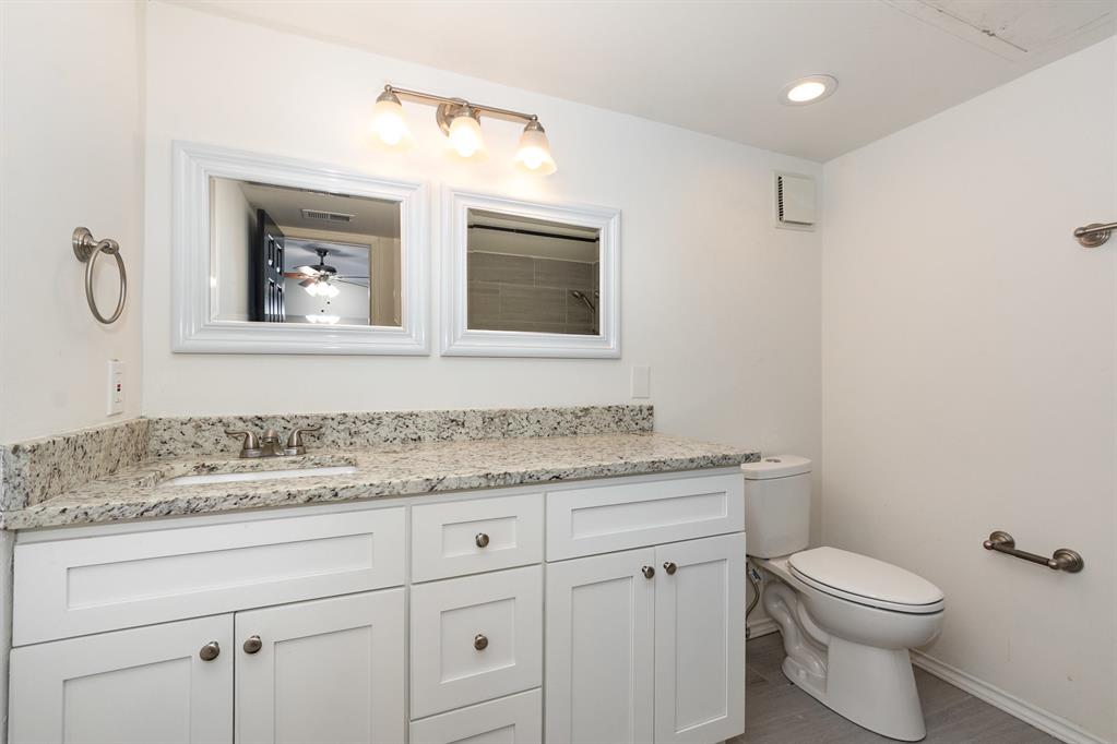 8750 Park Lane, Unit 151 Dallas, TX 75231 - Photo 16 of 33 a bathroom with a granite countertop toilet sink and mirror