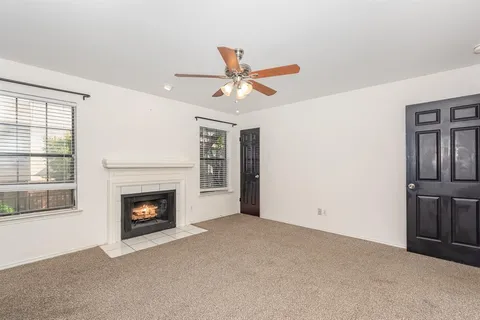 a view of empty room with fireplace and fan