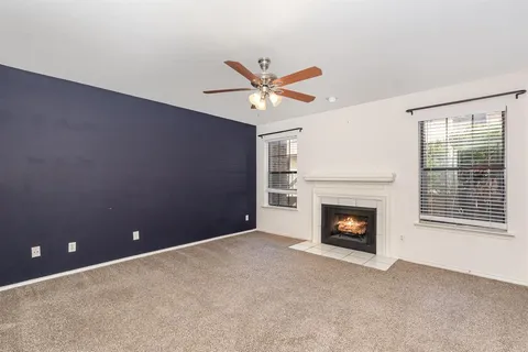 a view of a livingroom with a fireplace and a ceiling fan