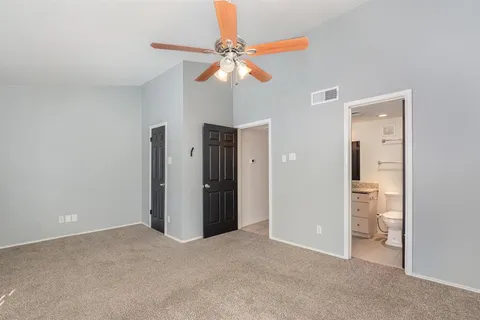 a view of an empty room with a ceiling fan