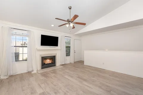 a view of empty room with fireplace and fan